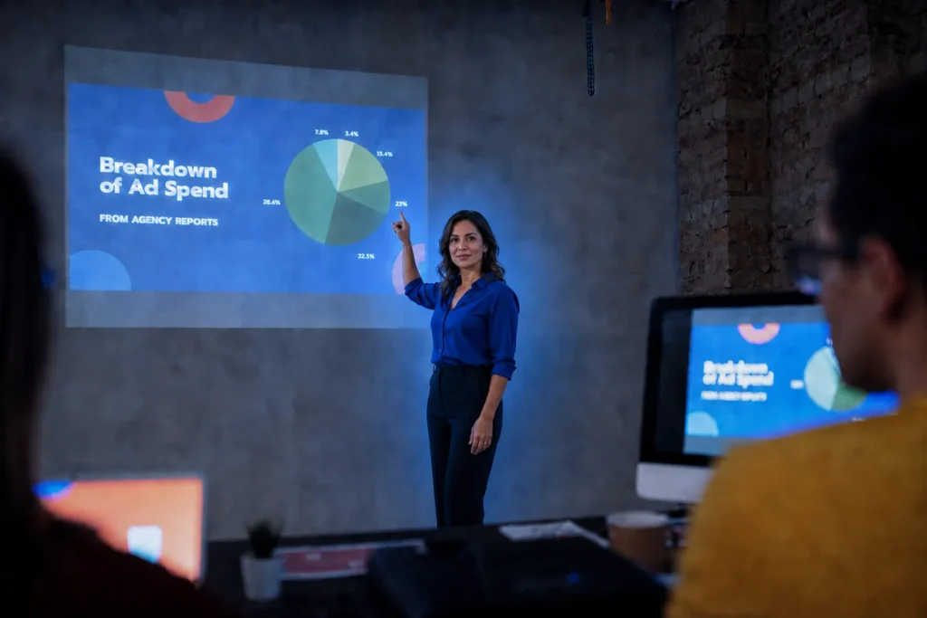 Profissional apresentando um gráfico para colegas em uma sala de reunião